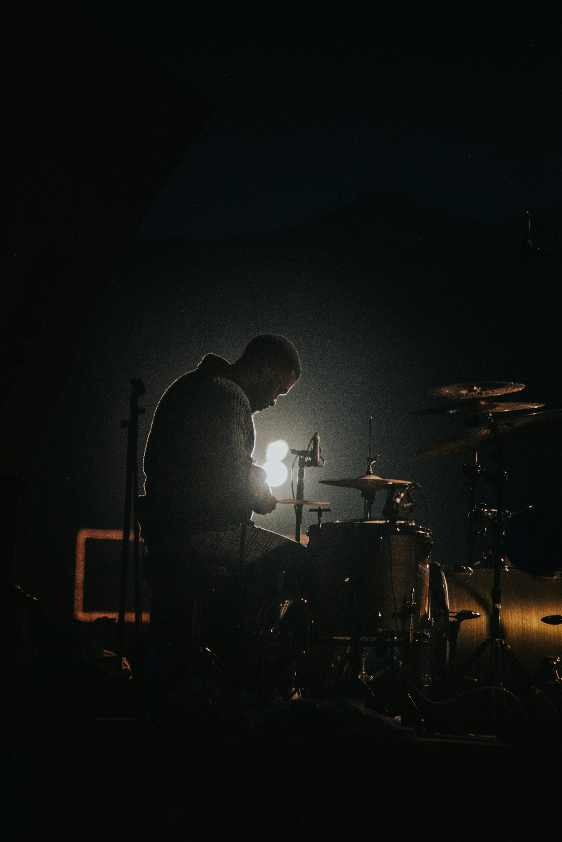 A musician silhouetted in stage light